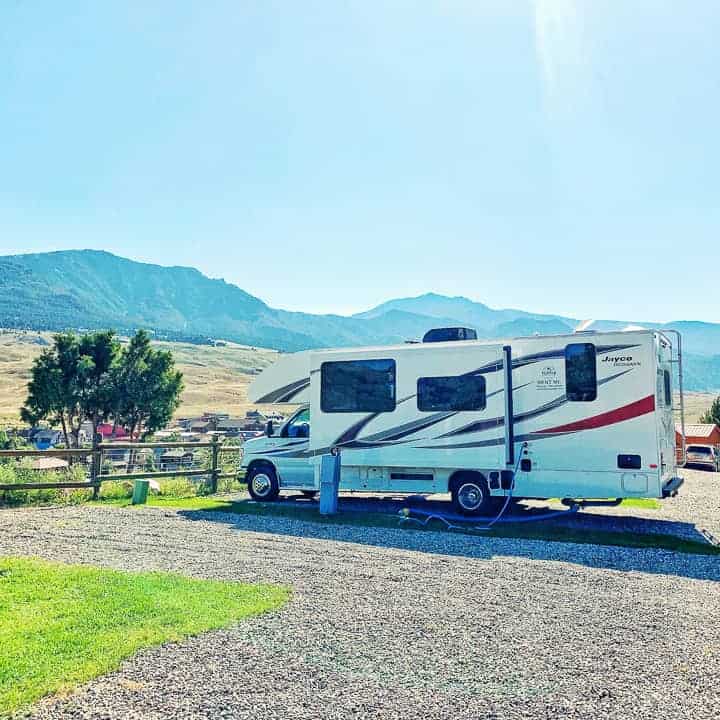 hilltop jayco RV shown in a campsite with mountains behind it. 