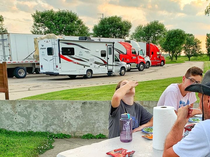 rv meals shown eaten at a rest stop picnic table with 3 people eating dinner.