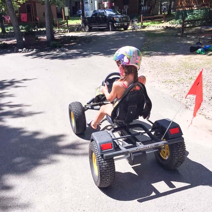 best camping in wisconsin showing a small girl on a pedal bike with a helmet on.