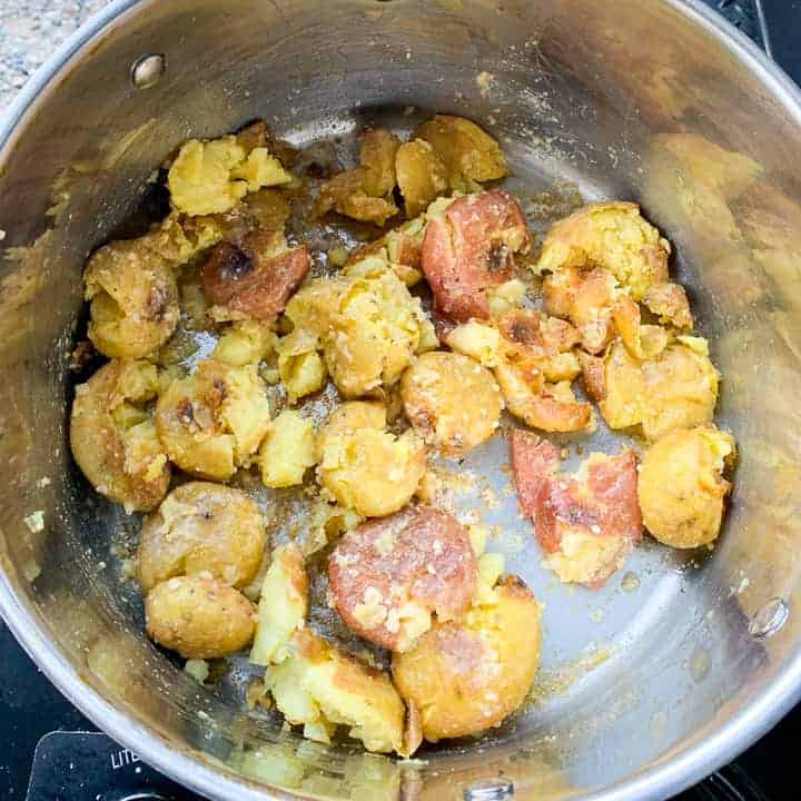 make ahead roasted potatoes shown in a stainless pot being reheated