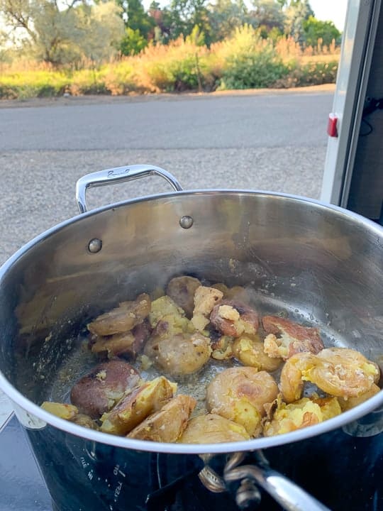 make ahead roasted potatoes being reheated on camp cookstove outside. 