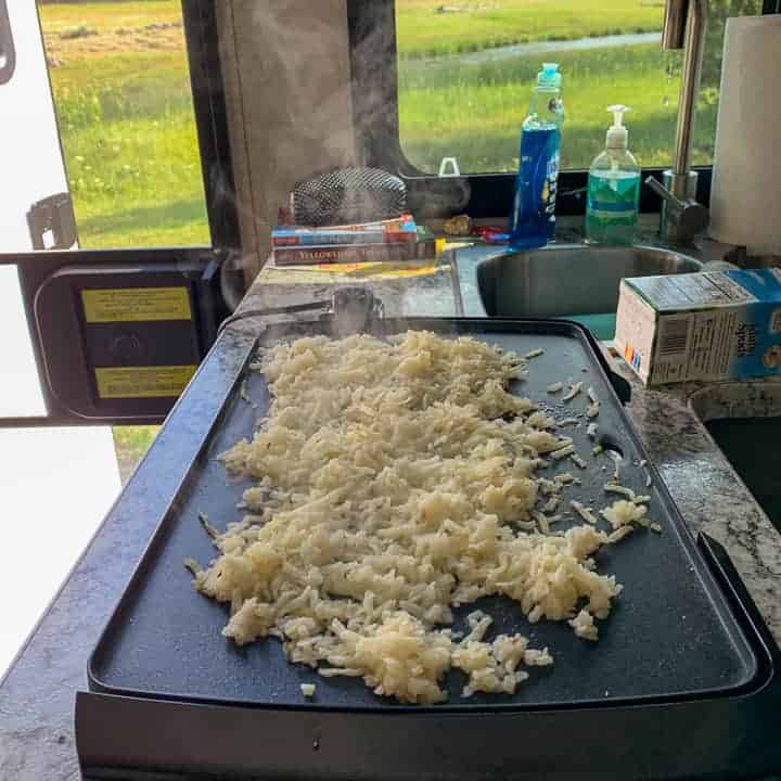 boxed hash browns on a grill being cooked in an RV kitchen