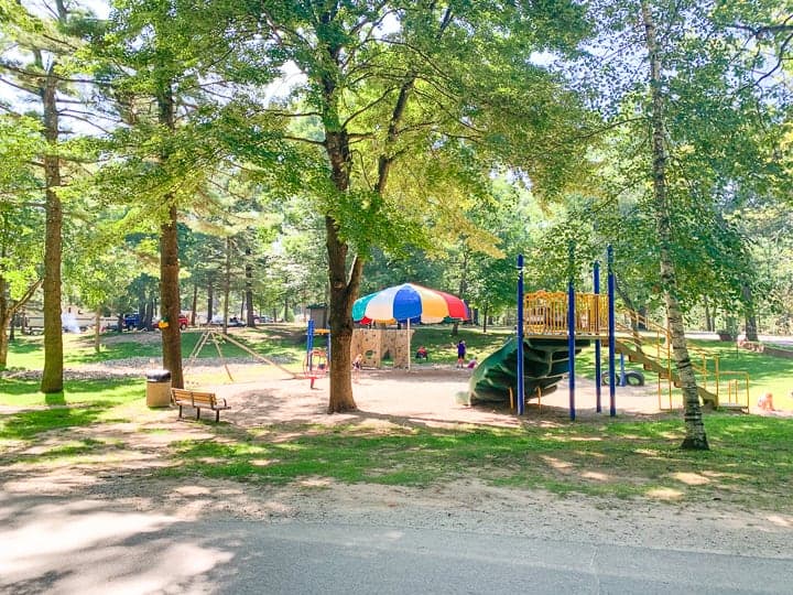 best camping in wisconsin showcasing one of 5 playgrounds set in the woods.