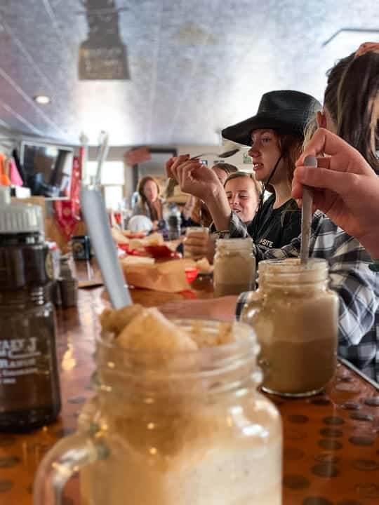 A person sitting at a table in a restaurant with an ice cream float