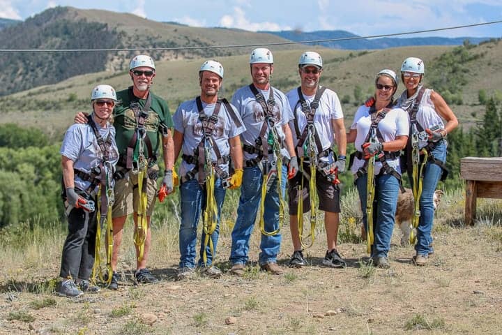 7 adults geared up to zipline.