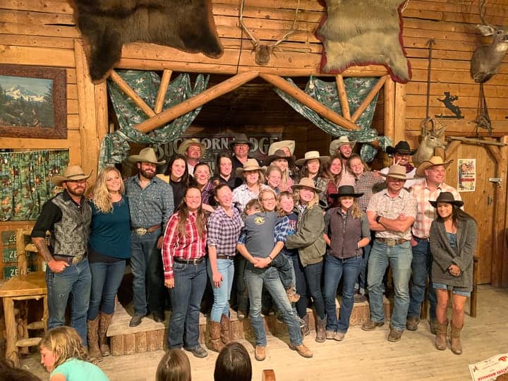 The whole Bar Lazy J guest ranch staff posing for a photo in the activities barn.