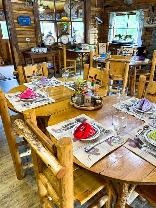 The all-inclusive dining experience showing the table set up in the dining hall with cowboy themed placemats, plates, and a bandana for a napkin.