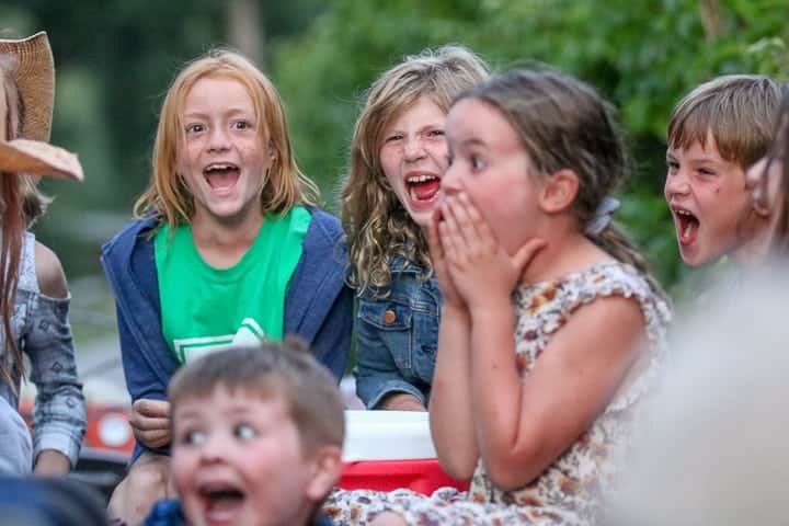 5 Laughing and smiling kids being shown at a family dude ranch enjoying the kid program.