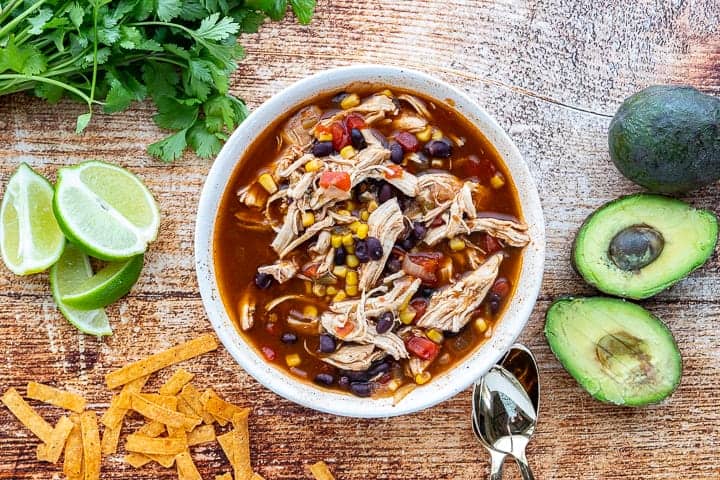 A bowl of food on a table, with chicken Tortilla soup