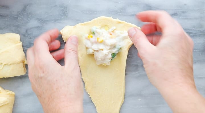 Chicken Pot Pie with Crescent Rolls, a crescent roll chicken pot pie recipe, showing pot pie filling on top of a crescent roll.