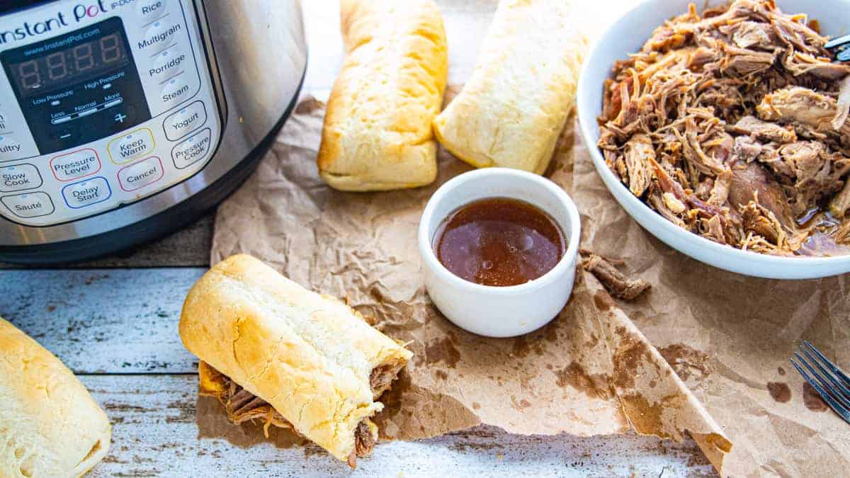 A sandwich sitting on top of a table with French dip sauce