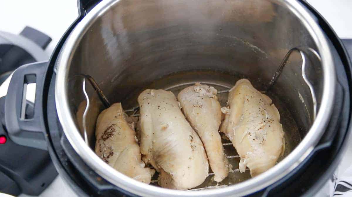 cooked chicken on top of a wire rack in an Instant pot. 