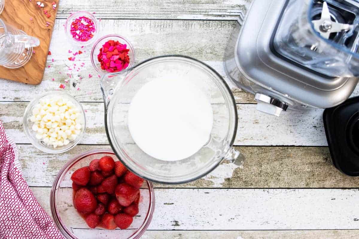 Valentine's Day Pink Hot Chocolate, a holiday recipe, showing ingredients in small bowls all on top of a wooden countertop.