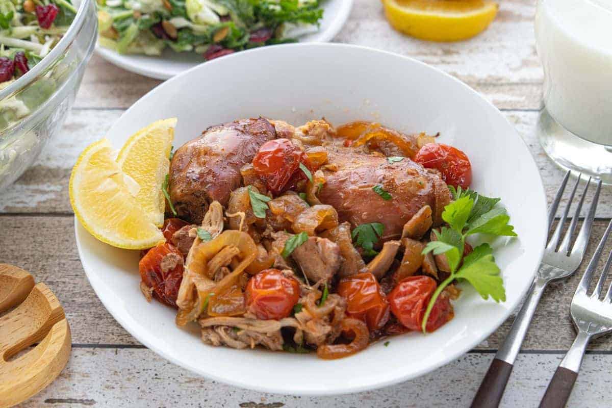 Veggie Packed Kid-Friendly Recipe showing slow cooker chicken and tomatoes in a serving dish on top of a countertop.