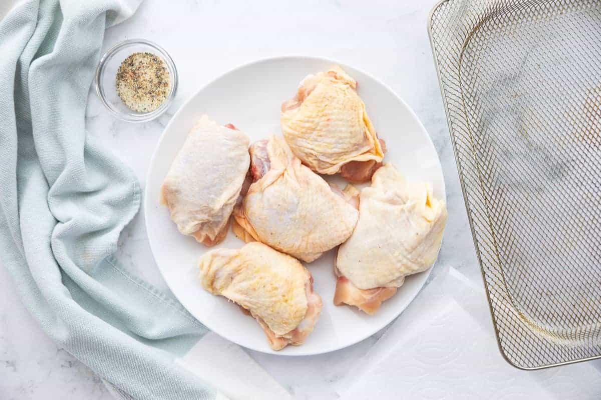 pieces of raw chicken thighs on a plate