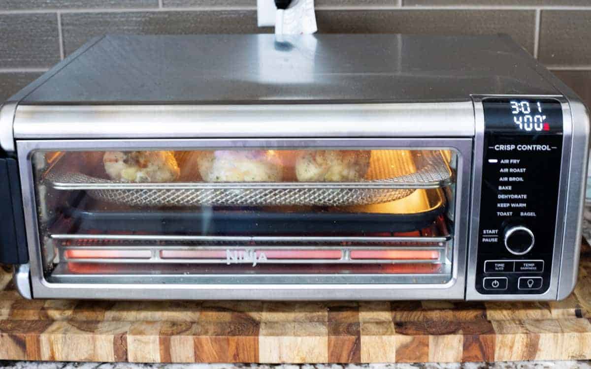 Air Fryer Chicken Legs showing chicken drumsticks air frying in the Ninja Foodi Air Fryer Oven.