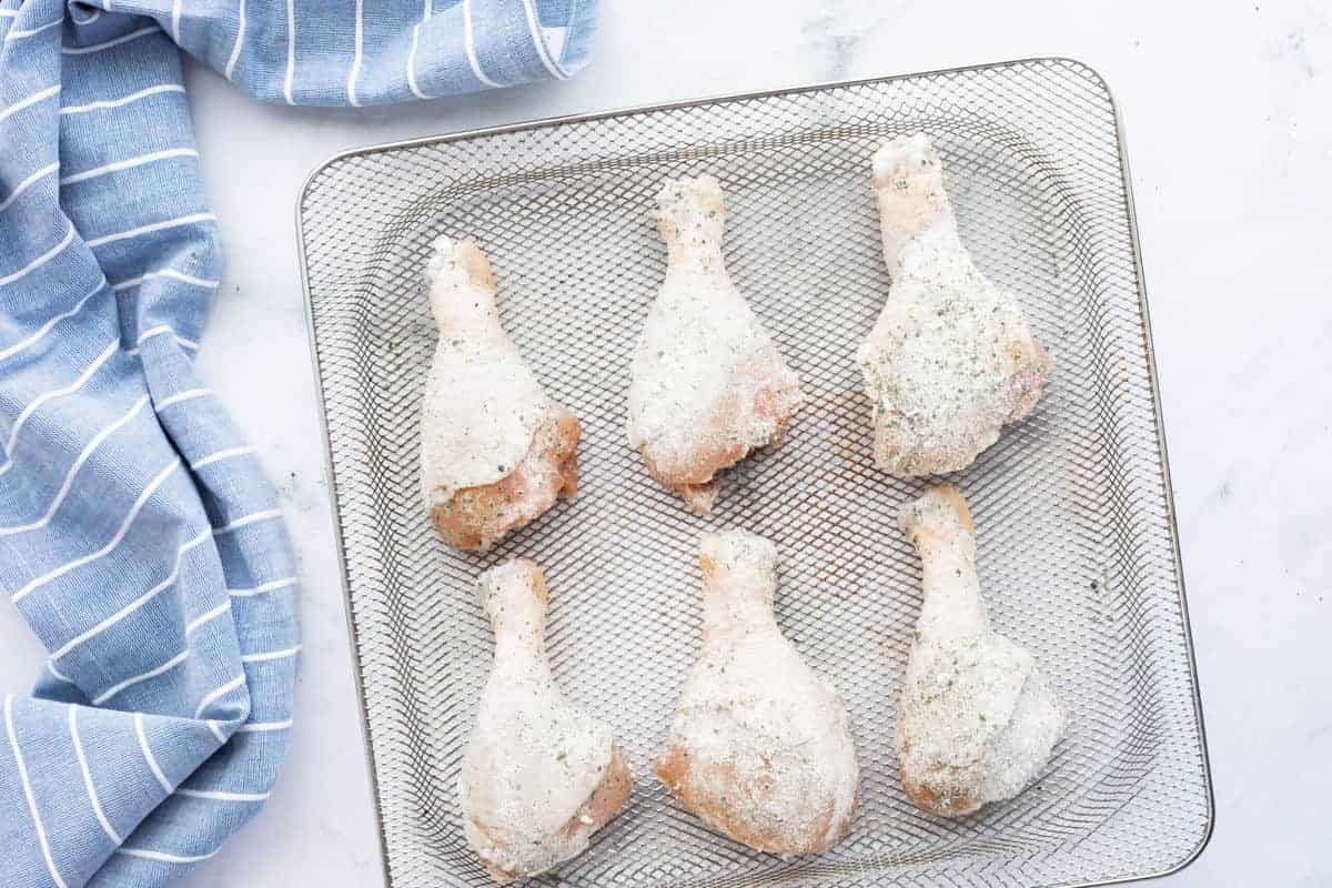 Air Fryer Drumsticks showing raw chicken legs on an air fryer rack.