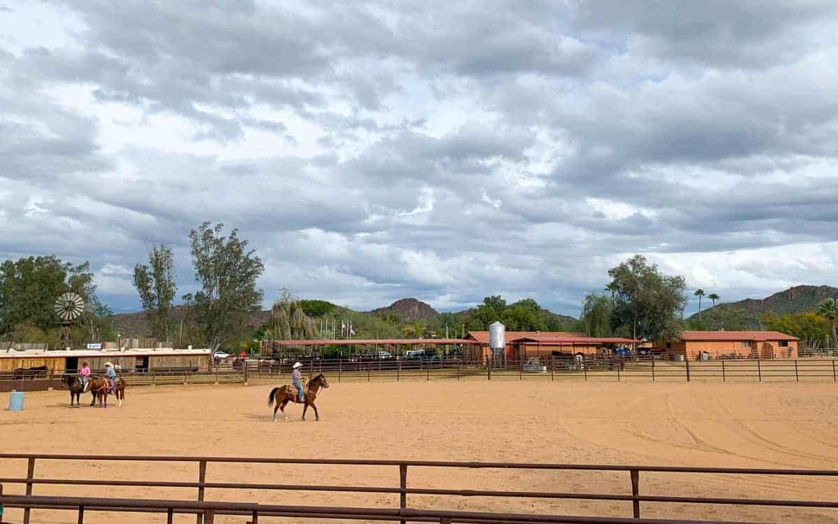 White Stallion Ranch, the Best All-Inclusive Resort in Arizona showing the ranch rodeo where ranchers are riding horses around the arena.