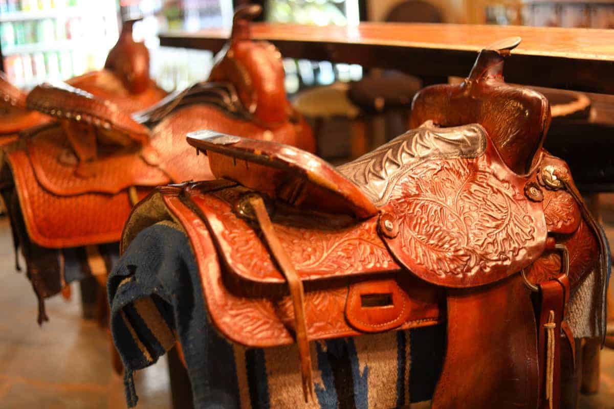 White Stallion Ranch, the Best All-Inclusive Resort in Arizona showing the bar at the dude ranch, which has saddles as the bar seats.