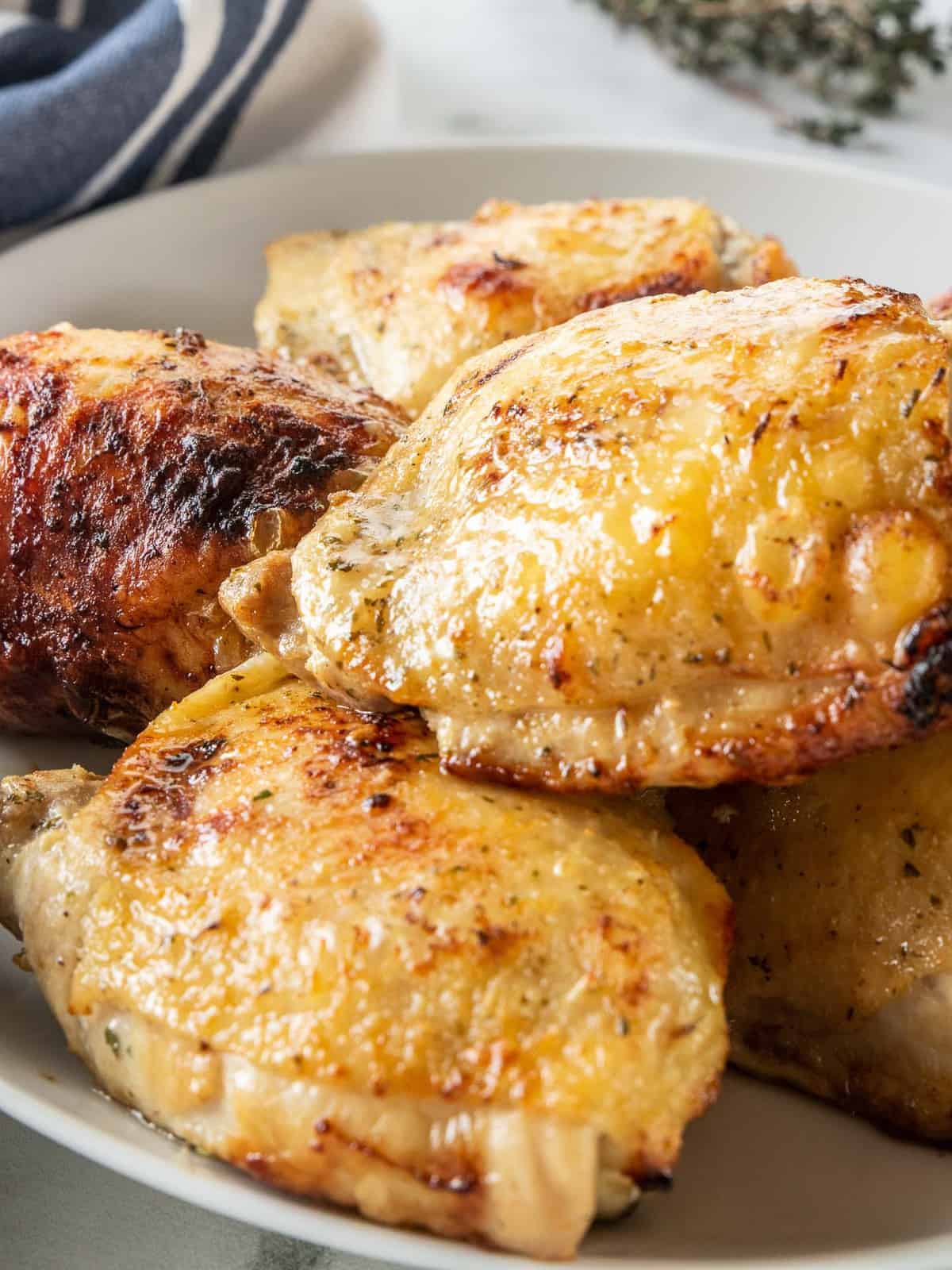 crisp chicken thighs on a white plate. 