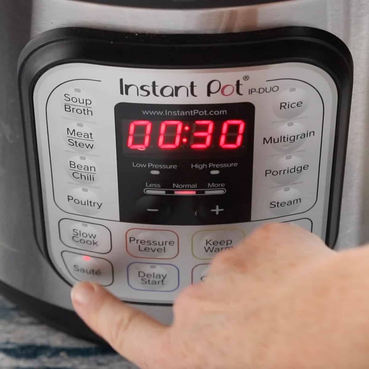 front panel of instant pot showing the sauté button being pressed.