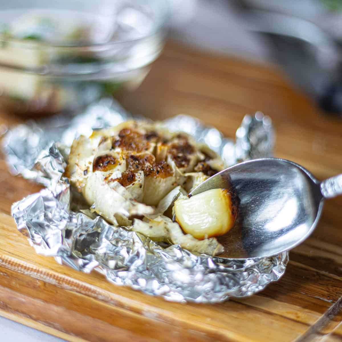 roasted garlic in tinfoil scooped out with spoon