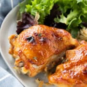 chicken thigh on a plate with a salad