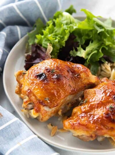 chicken thigh on a plate with a salad
