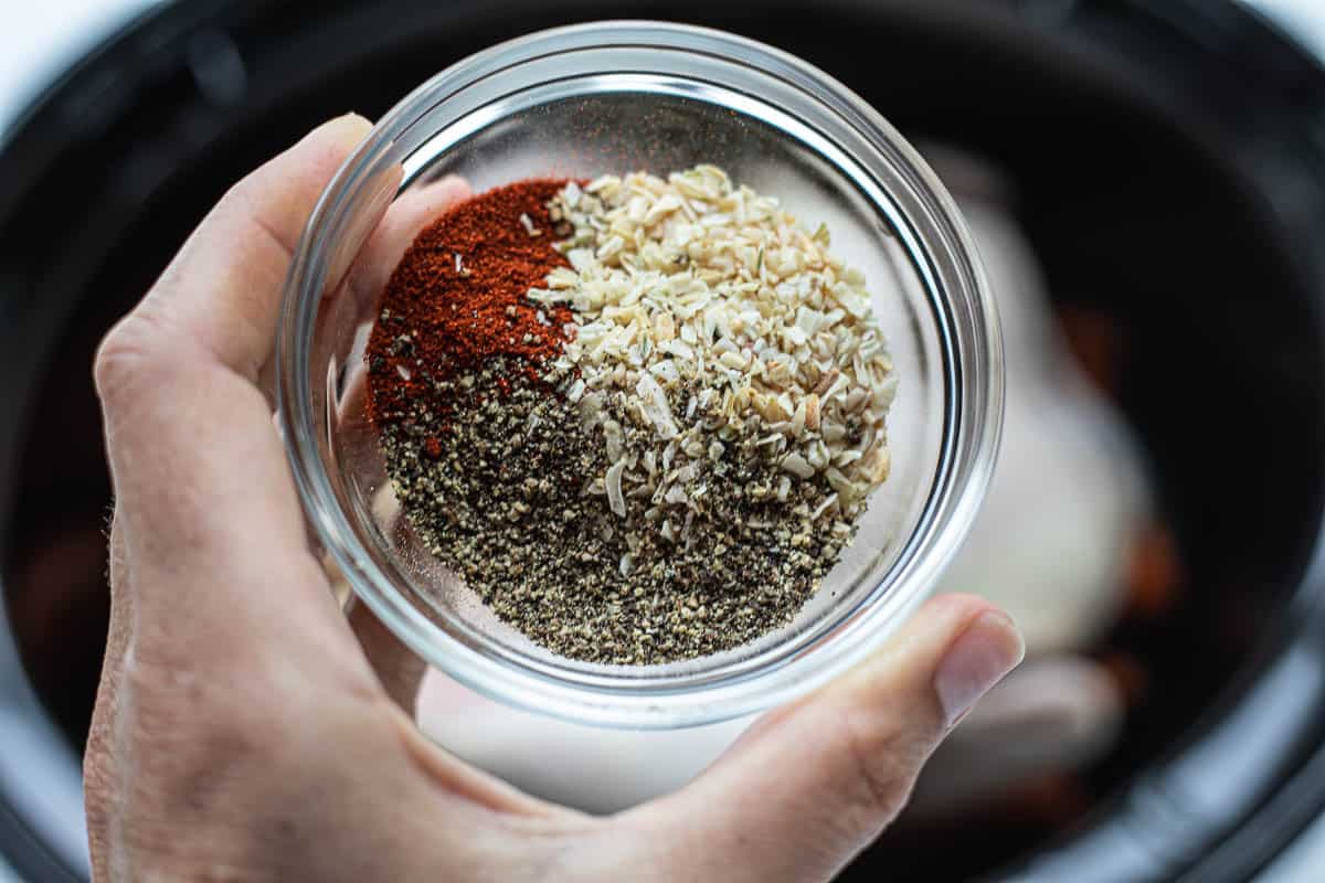 A small jar filled with a combination of spices. 