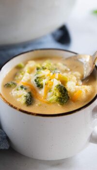 A bowl of soup with broccoli and cauliflower
