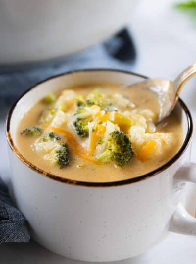 A bowl of soup with broccoli and cauliflower