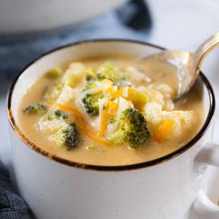 A bowl of soup with broccoli and cauliflower