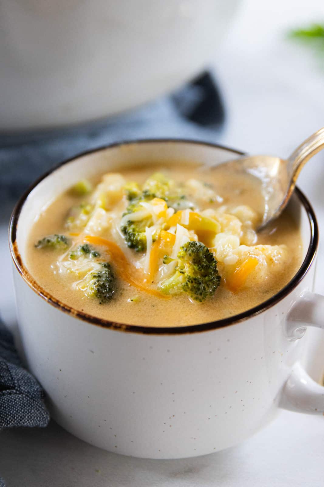 A bowl of soup with broccoli and cauliflower