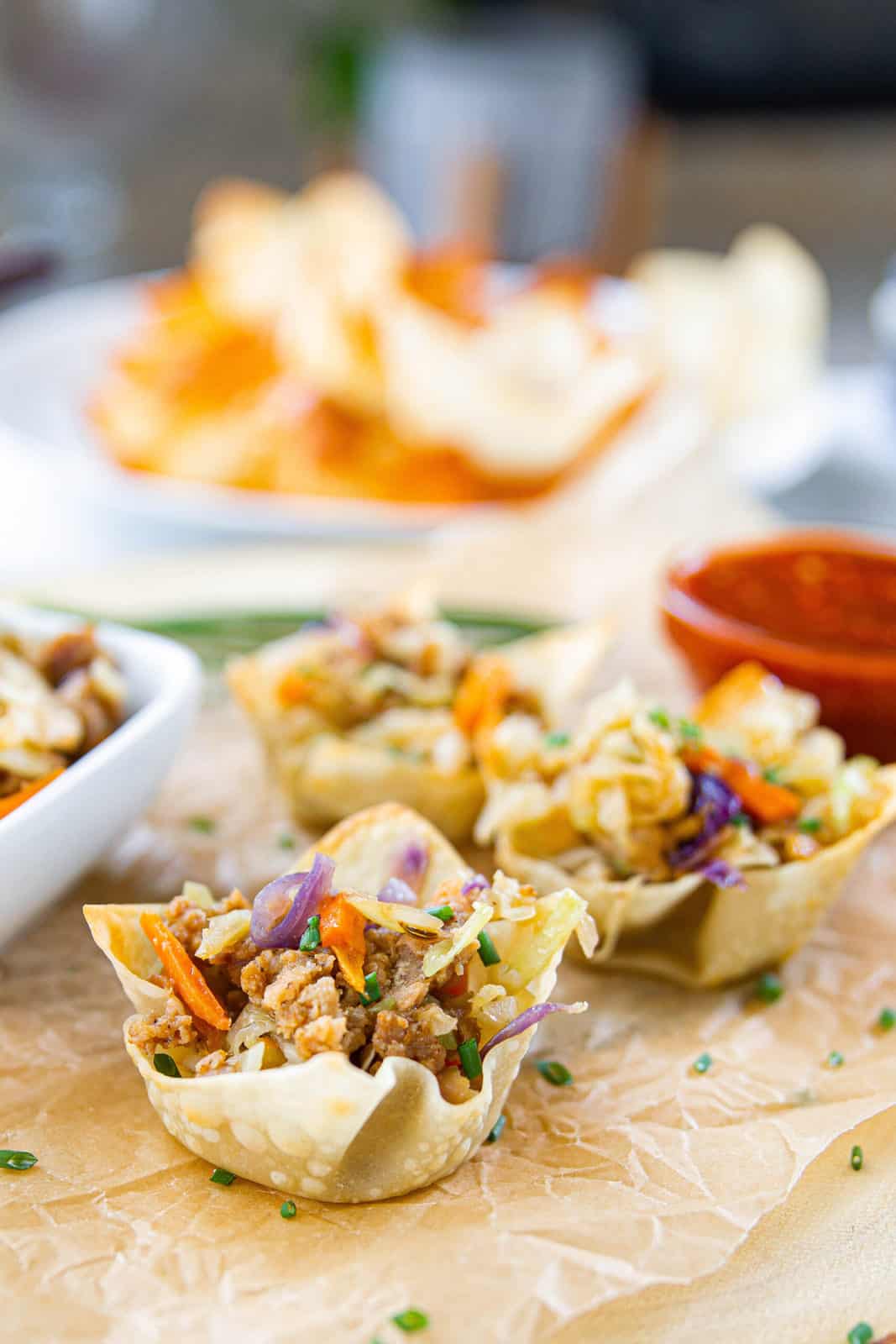 A wonton wrapper is cooked into a cup and is filled with pork egg roll filling.