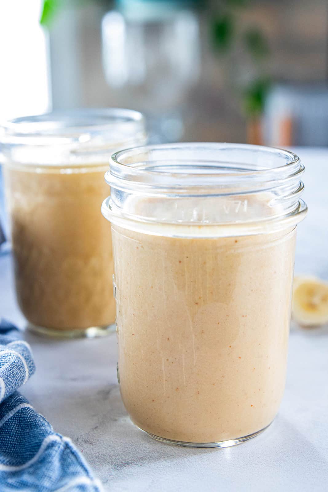 Two full glass jars filled with peanut butter powder smoothie.