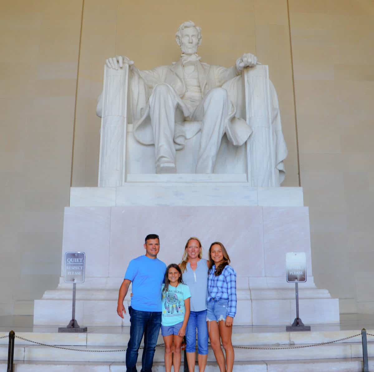 A white family with two teen daughters in front of the Lincoln statue in Washington DC.