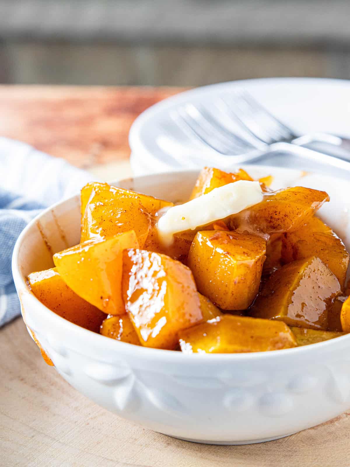 Maple roasted butternut squash in a white serving bowl.