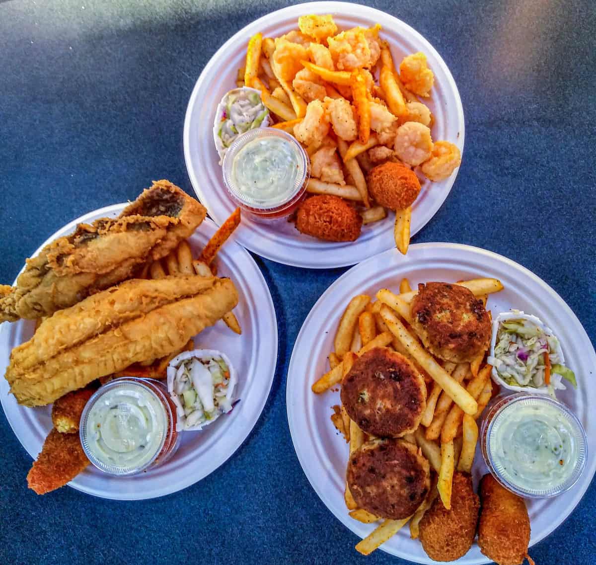 Three plates of fried seafood with sides in Charleston NC.