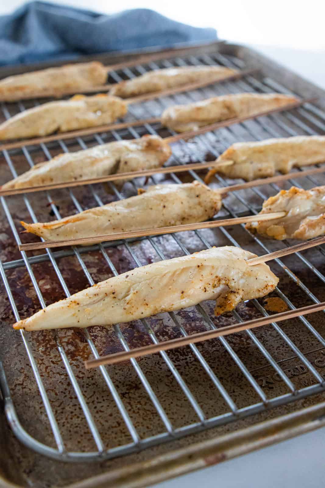 Chicken sticks being shown on a baking sheet.