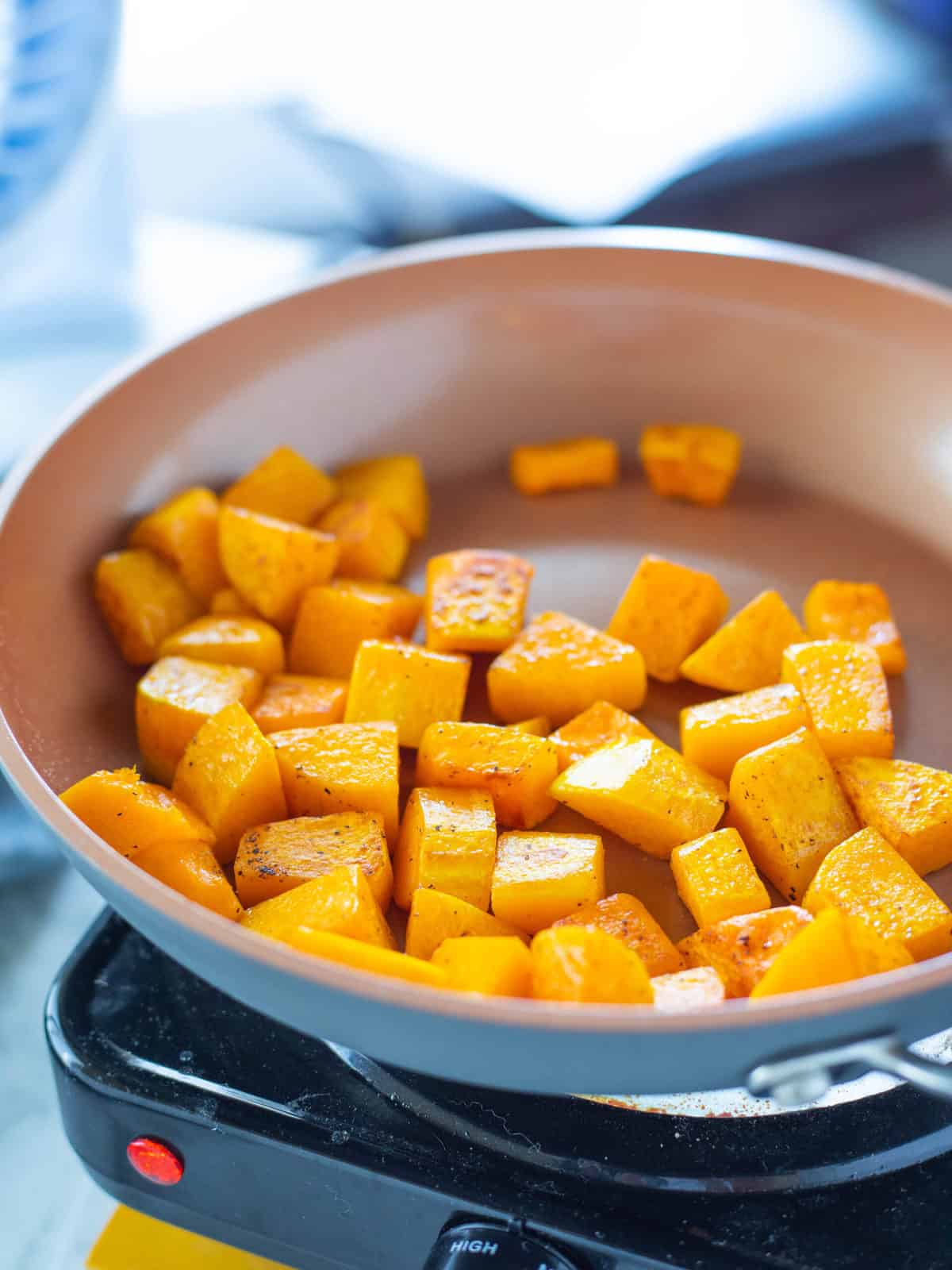 Chopped squash being shown in a medium sized skillet.