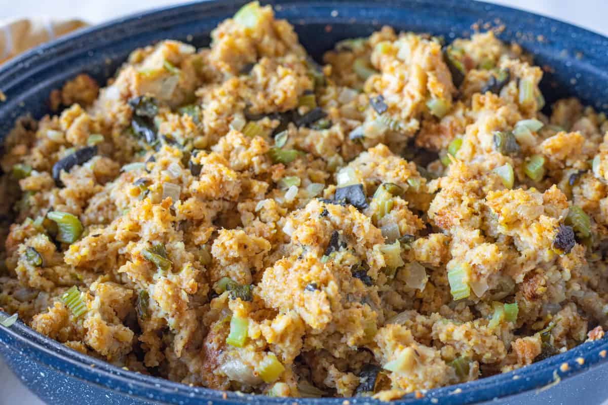 Easy Cornbread Stuffing being shown in a large blue roasting pan. 