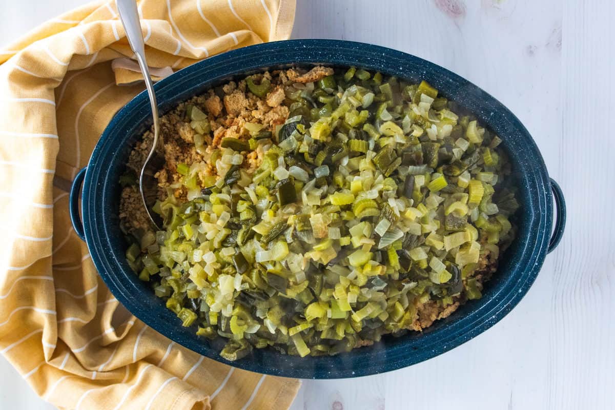 Ingredients for homemade cornbread stuffing being shown in a large blue roasting pan. 