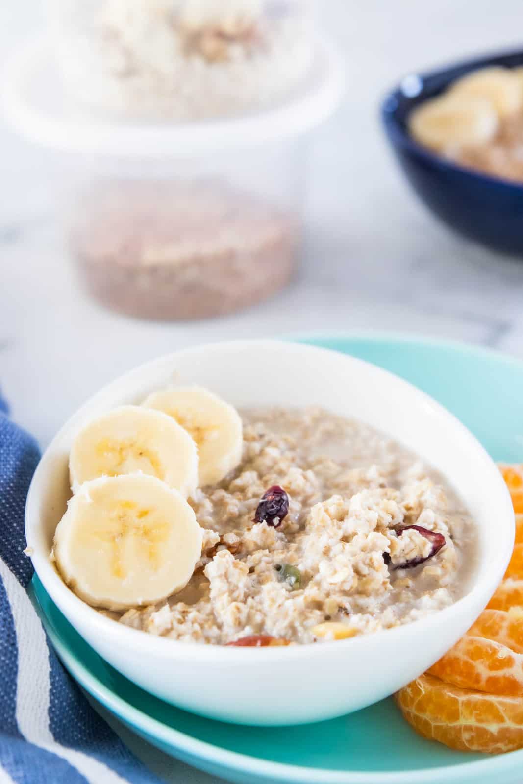 Oatmeal in a white bowl topped with slices of banana.