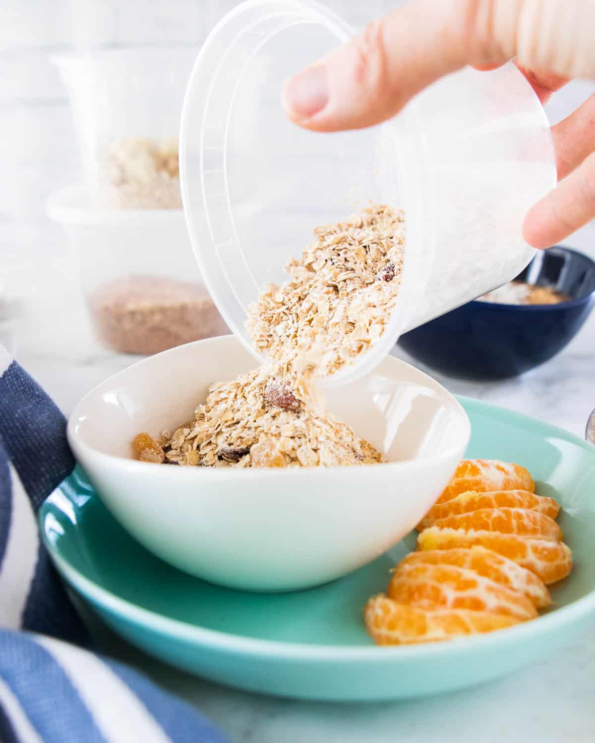 Oats being poured into a white bowl. 