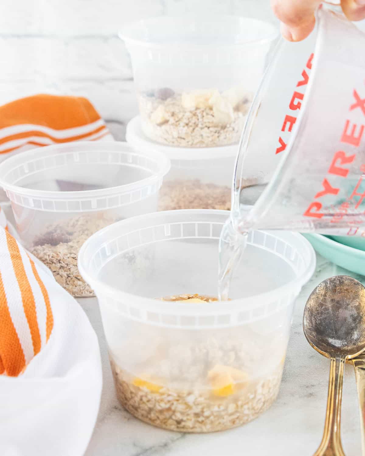 Hot water being poured into a container filled with oats. 