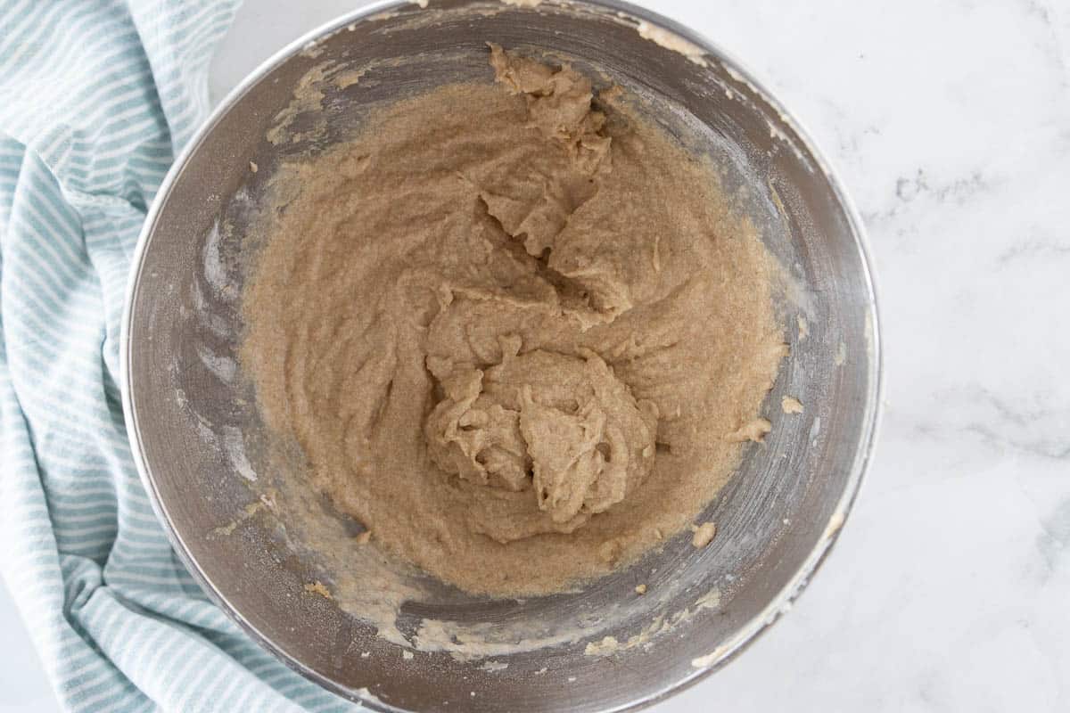 Cupcake batter in a mixing bowl that is on top of a granite countertop.