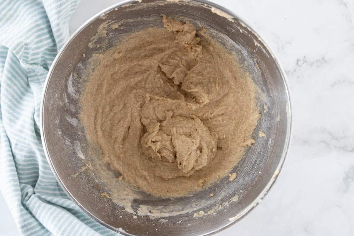 Cupcake batter in a mixing bowl that is on top of a granite countertop. 