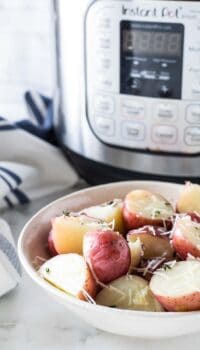 a bowl of red potatoes next to an instant pot