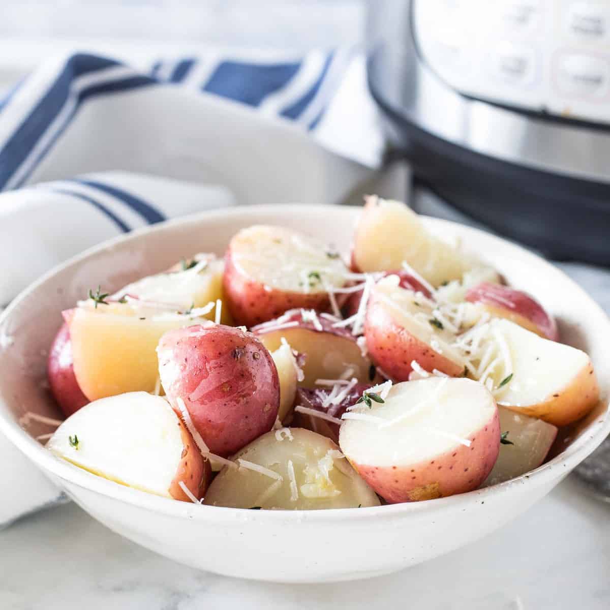 Red potatoes sprinkled with parmesan cheese in a bowl. 