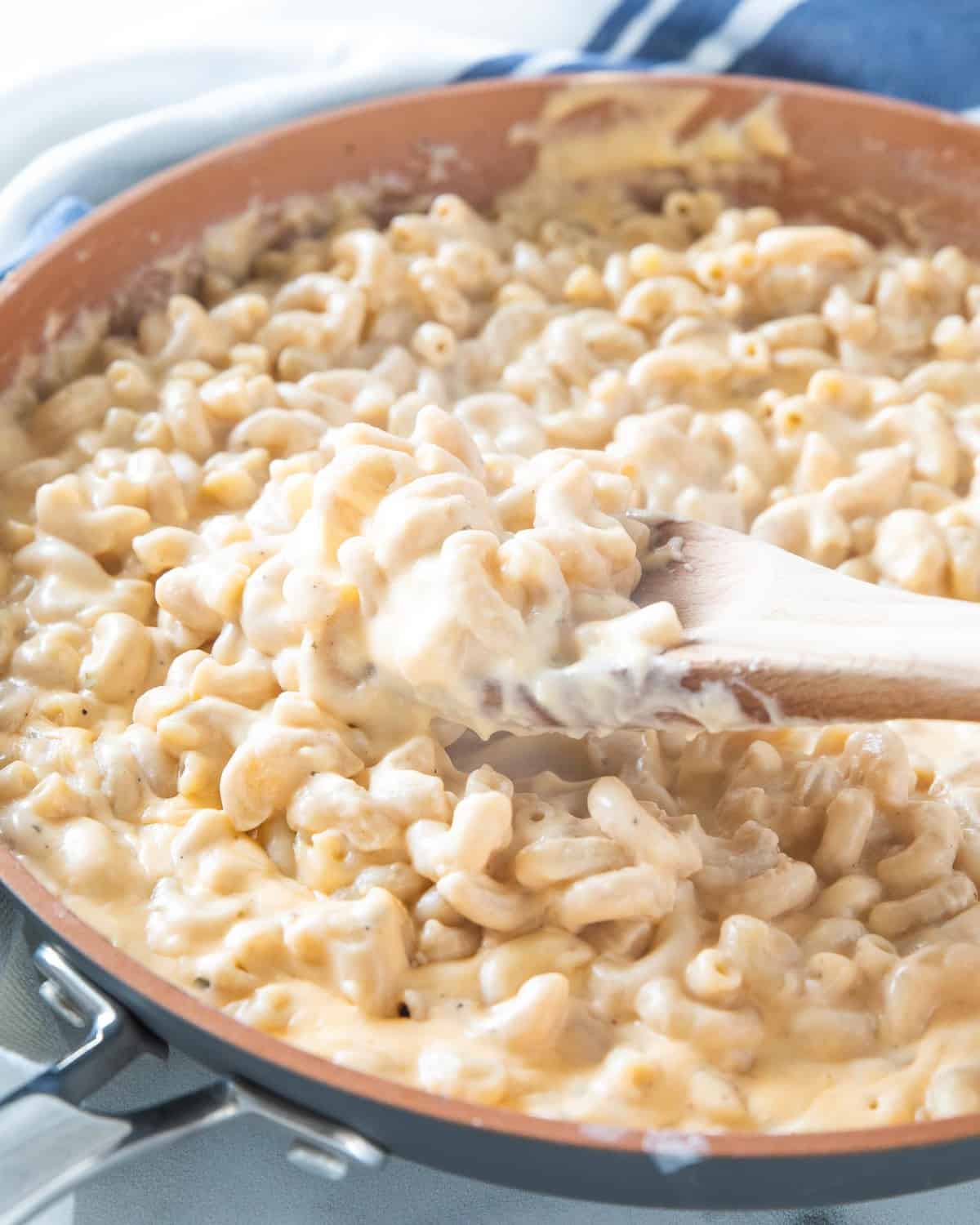 Low sodium Mac and cheese being stirred in a saucepan.